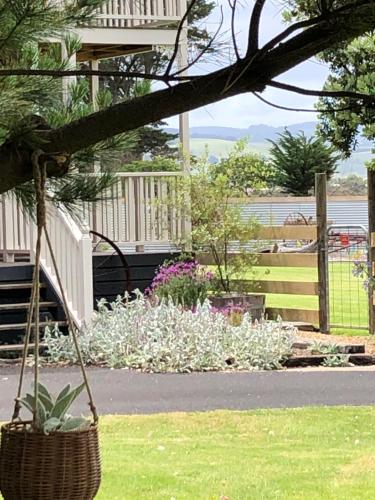 a garden with white flowers and a fence at Sea Change Guesthouse in Apollo Bay