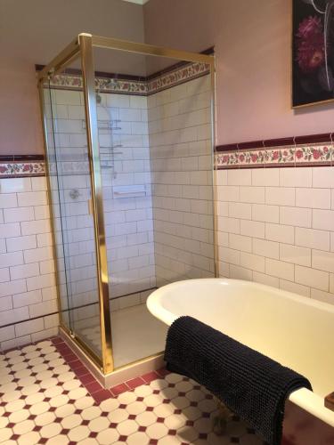 a bathroom with a tub and a glass shower at Sea Change Guesthouse in Apollo Bay