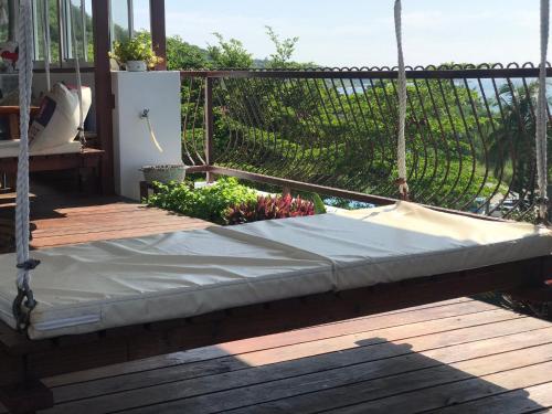 a mattress on a porch with a fence at Na Jie 17 in Donghe