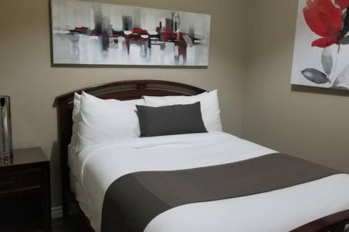 um quarto com uma cama com lençóis brancos e uma flor vermelha em Cozy 1-BDR Suite #20 by Amazing Property Rentals em Gatineau