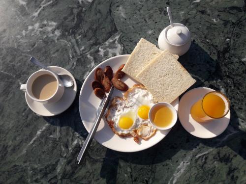 カトマンズにあるホテル ファミリー ホームの卵料理、トースト、コーヒー2杯