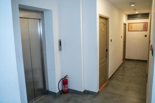 a hallway with a fire hydrant next to a door at Hotel Beebiz Guindy in Chennai