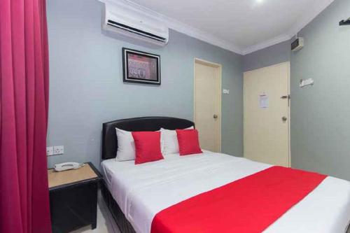una camera da letto con un grande letto con cuscini rossi di Puteri Ampang Hotel ad Ampang