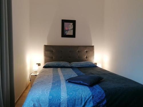 1 dormitorio con 1 cama azul y 2 almohadas en Apartment Chiara en Labin