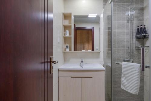 a bathroom with a sink and a shower with a mirror at Suzhou Jade Snow Lodge in Suzhou