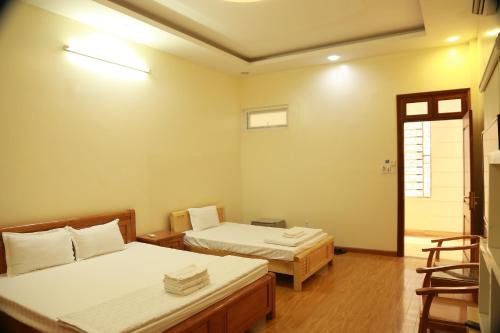 a room with two beds and a chair in it at Duong Ha Hotel in Cao Bằng