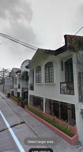 a house on a street next to a street larger area at Grand Traveler Suite Inc in Manila