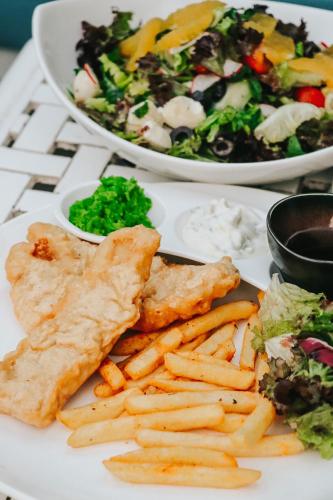 a white plate with fish and french fries and a salad at Radisson Blu Resort, Fujairah in Dibba