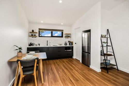 a kitchen with a table and a refrigerator at Old Bull Creek Luxury Retreat in Strathalbyn