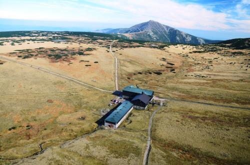 an aerial view of a train in a field with a mountain at Luční bouda in Pec pod Sněžkou