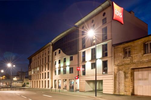 un bâtiment avec un panneau d'autobus sur son côté dans l'établissement ibis Bordeaux Centre - Gare Saint-Jean, à Bordeaux