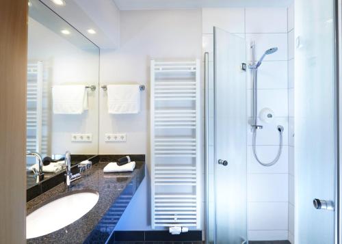 La salle de bains est pourvue de 2 lavabos et d'une douche. dans l'établissement Hotel Schünemann, à Steinfurt