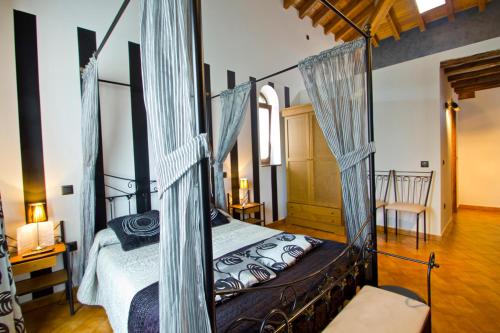 a bedroom with a four poster bed with blue drapes at Posada La Fabula in Santillana del Mar