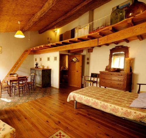 a bedroom with a bed and a wooden floor at La Vigne Bleue in Olonzac