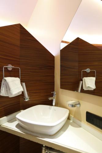 a bathroom with a white sink and a mirror at Dragonfly Hotel - The Art Hotel in Mumbai