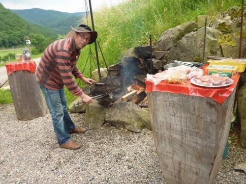 a man standing next to a fire with a grill at Wäldebauernhof in Gutach