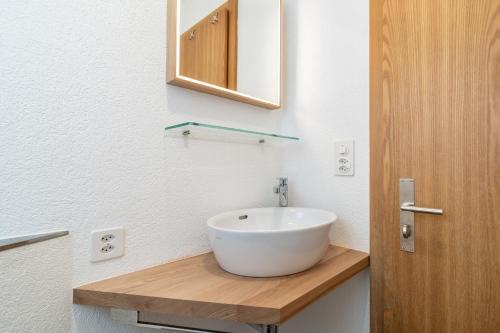 ein Badezimmer mit einem weißen Waschbecken auf einer Holztheke in der Unterkunft Edelweiss Ner A5 in Flims