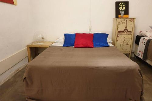 een slaapkamer met een groot bed met rode en blauwe kussens bij El Piset de Amposta - Delta del Ebro in Amposta