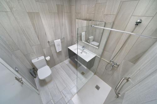 a bathroom with a toilet and a sink and a mirror at Maspalomas Lago Canary Sunset in Maspalomas
