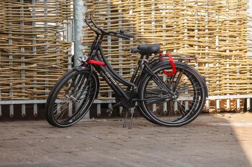 ein schwarzes Fahrrad, das vor einer Wand geparkt ist in der Unterkunft Houseboat Little Amstel in Amsterdam