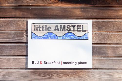a sign on a wooden wall with a little angeledbidbidbidbidiest at Houseboat Little Amstel in Amsterdam