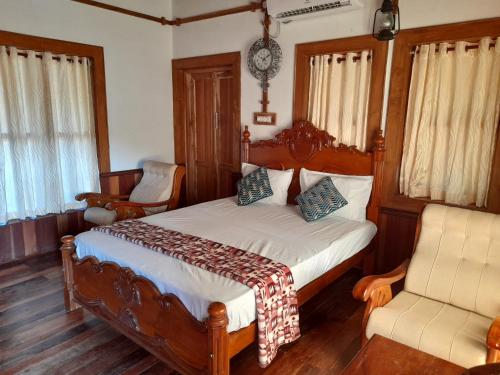 a bedroom with a bed and two chairs at Riverlap homestay in Nīleshwar