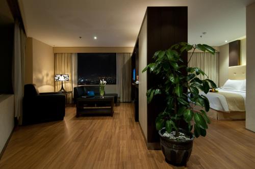 a hotel room with a bed and a potted plant at Aria Gajayana in Malang