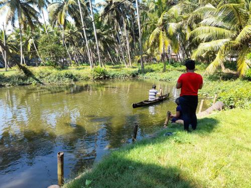 two people in a boat on a river at Riverlap homestay in Nīleshwar