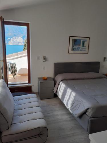 a bedroom with a bed and a large window at Residence Le Palme appartamenti in Malcesine