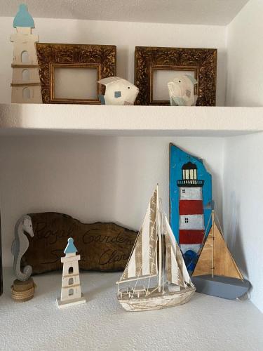 a shelf with a model of a lighthouse and a boat at Royal Garden Santa Clara in Jávea
