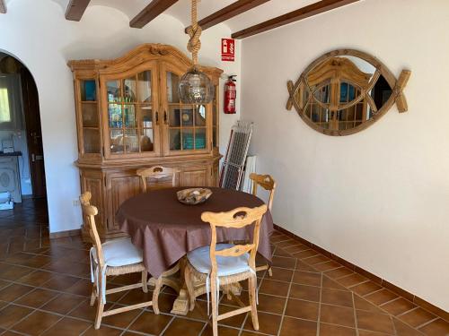 a dining room with a table and a china cabinet at Royal Garden Santa Clara in Jávea