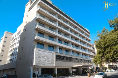 ein großes weißes Gebäude in einer Stadtstraße in der Unterkunft The Jewel Hotel in Manama