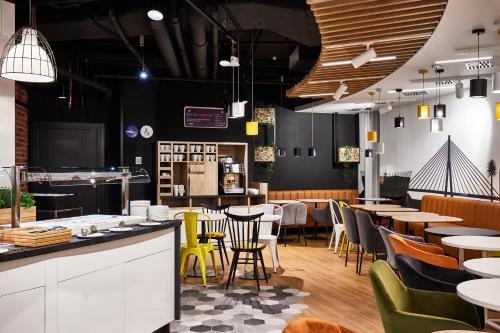 a restaurant with tables and chairs and a bar at Holiday Inn Express - Warsaw - The HUB by IHG in Warsaw