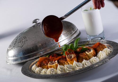 a table with a plate of food on a table at Wellborn Luxury Hotel in Kocaeli
