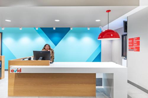 a woman sitting at a desk with a laptop at avid hotel - Bentonville - Rogers by IHG in Bentonville