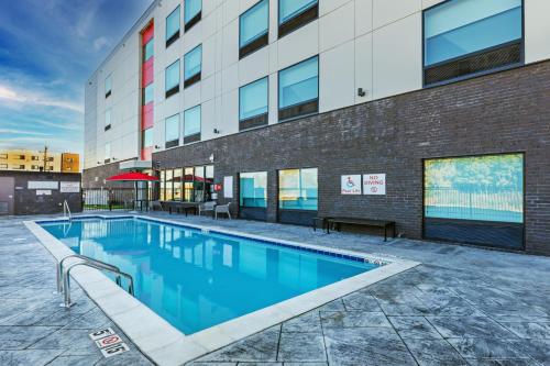 una piscina di fronte a un edificio di avid hotels - Bentonville - Rogers, an IHG Hotel a Bentonville