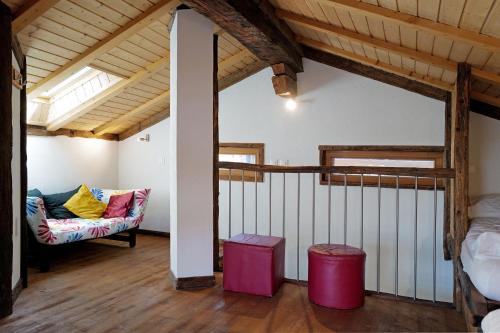 a room with a couch and a chair in a attic at Bois de Lune in Mase