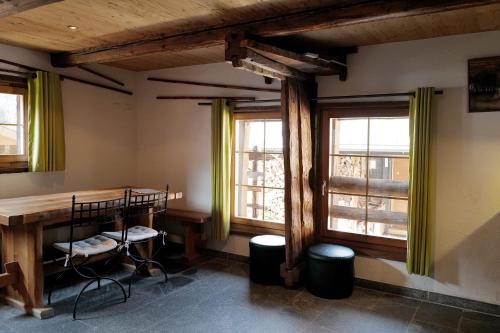 Cette chambre dispose d'une table en bois et de deux fenêtres. dans l'établissement Bois de Lune, à Mase