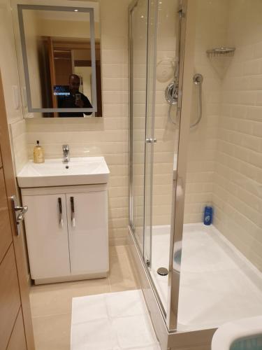 Ein Mann fotografiert ein Bad mit Dusche in der Unterkunft London Luxury Apartments 5 min walk from Ilford Station, with FREE PARKING FREE WIFI in Ilford