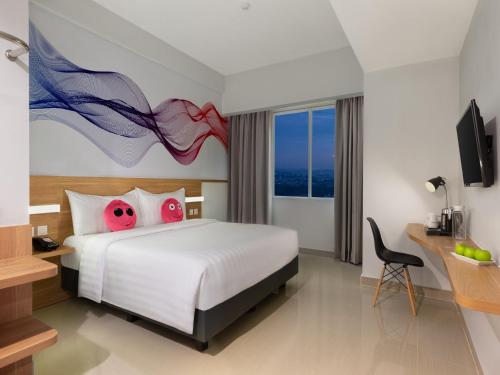 a hotel room with a bed and a desk with a computer at favehotel Karawang in Karawang