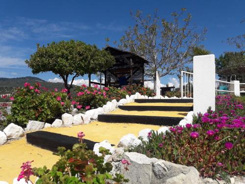 a garden with flowers and a gazebo at La Choza De Mamuyo in Montefrío