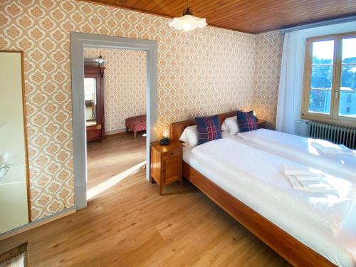a bedroom with a large bed and a mirror at DU GLACIER Boutique & Traditions Hotel in Fiesch