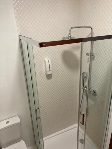 y baño con ducha y puerta de cristal. en Buddies Family Room, en Aveiro