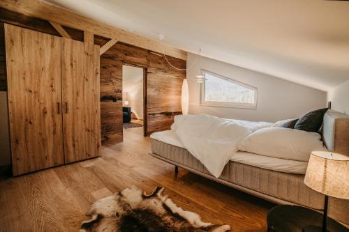 Haus Wildmoos في سانكت مارتن باي لوفر: غرفة نوم بسرير كبير وجدران خشبية