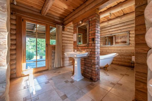 a bathroom with a sink and a bath tub and a window at Alauso Slenis in Sudeikiai
