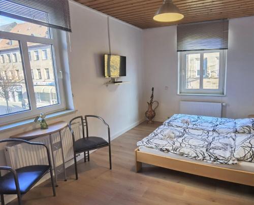 Schlafzimmer mit einem Bett, einem Tisch und Stühlen in der Unterkunft Privatzimmer Fürth Zentrum in Fürth