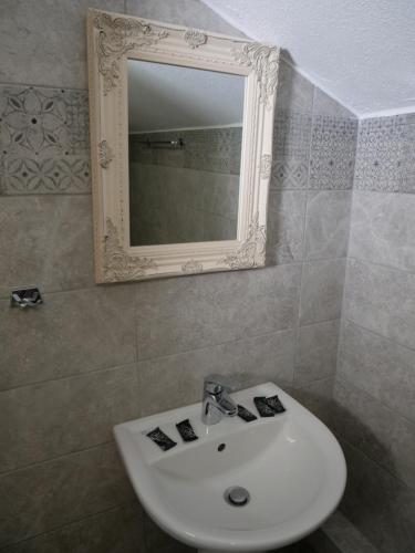 La salle de bains est pourvue d'un lavabo blanc et d'un miroir. dans l'établissement Villa Giotis, à Skala Sotiros