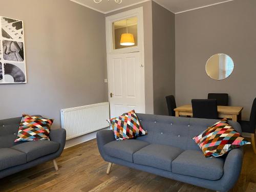 a living room with a blue couch and two pillows at innerCityLets - Royal Mile in Edinburgh