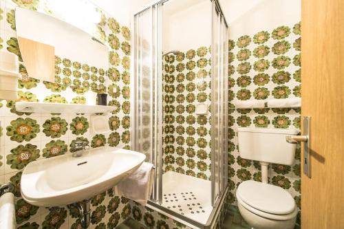 La salle de bains est pourvue de toilettes, d'un lavabo et d'une douche. dans l'établissement Gasthaus Gasteiger, à Lagundo