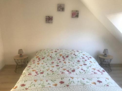 een slaapkamer met een bed met een bloemenbed bij Gîte "Le Drouzet" in Le Chazal